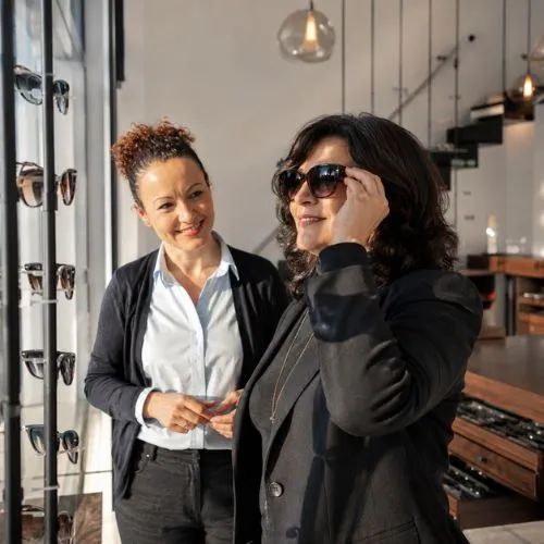 Nuria Cano asesorando a una clienta sobre gafas de sol progresivas en Sensia Óptica, Vera