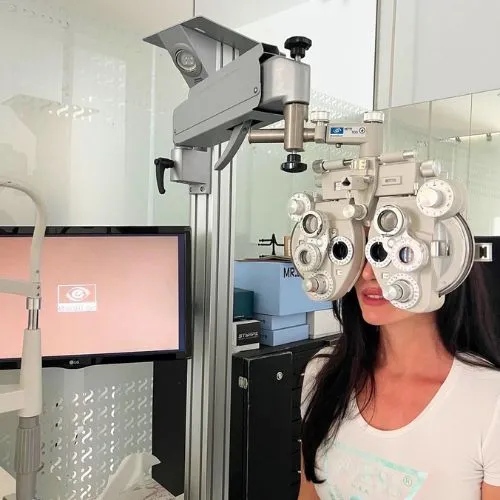 Clienta realizando un examen de graduación con foróptero para gafas progresivas en Sensia Optics, Vera