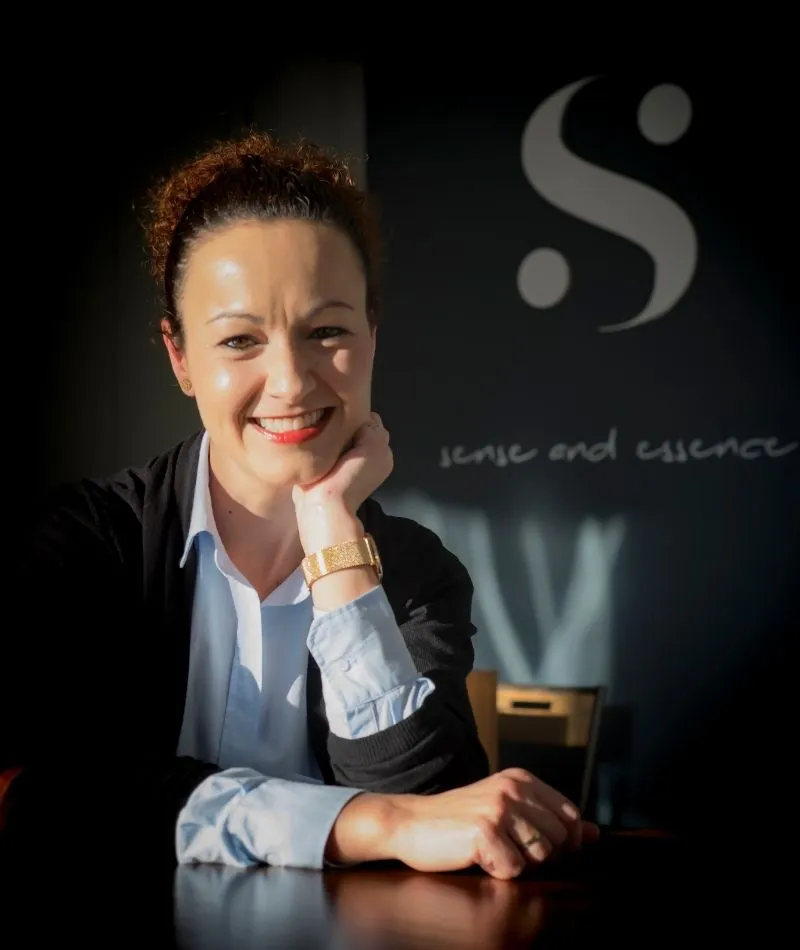 Nuria Cano sonriendo junto al logotipo de Sensia Optics en Vera