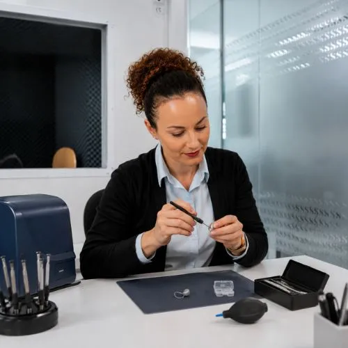 Nuria Cano realizando una reparación y mantenimiento de audífonos en Sensia Óptica, Vera