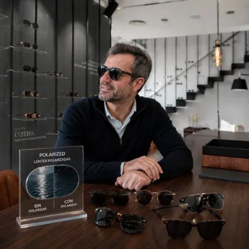 Cliente probando gafas de sol polarizadas con muestra comparativa en Sensia Optics, Vera